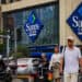 Personas caminando por las calles de Estados Unidos frente a un Sams club
