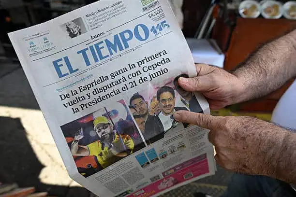 Persona sosteniendo un periodico colombiano en sus manos