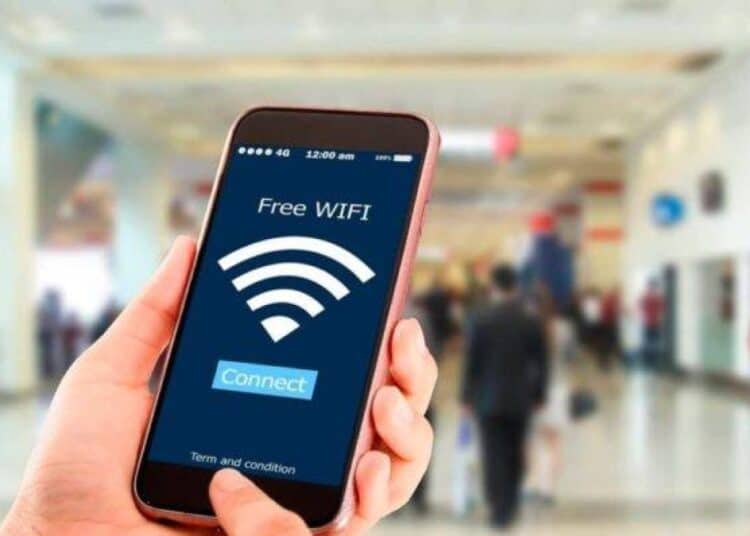 Persona usa un teléfono inteligente conectado a una red Wi-Fi pública en un espacio comercial
