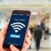Persona usa un teléfono inteligente conectado a una red Wi-Fi pública en un espacio comercial