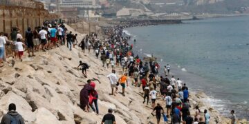 Jóvenes migrantes saltando la valla fronteriza entre Marruecos y la ciudad española de Ceuta