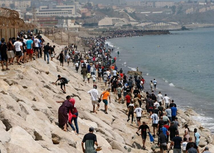 Jóvenes migrantes saltando la valla fronteriza entre Marruecos y la ciudad española de Ceuta