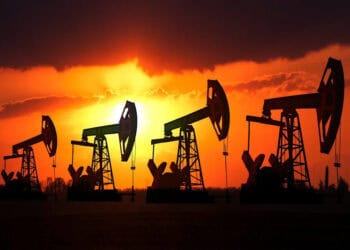 Torres de perforación petrolera operando al atardecer en un yacimiento de crudo