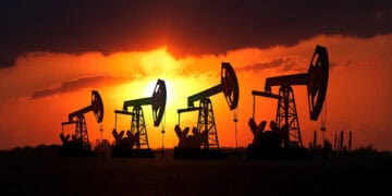 Torres de perforación petrolera operando al atardecer en un yacimiento de crudo