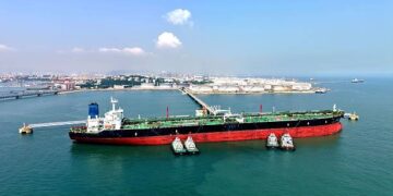 Petrolero navegando en el mar Rojo con tableros de precios del crudo al alza