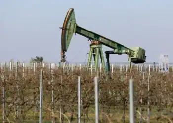 Bomba de extracción de petróleo en un campo bajo cielo despejado al atardecer