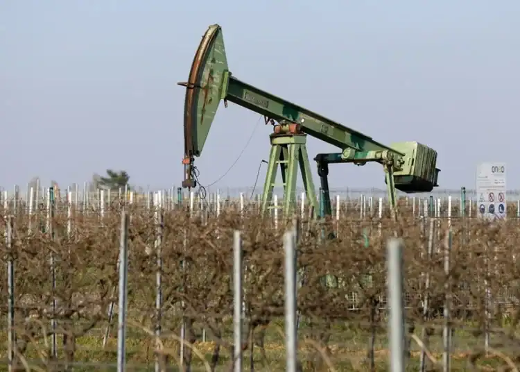 Bomba de extracción de petróleo en un campo bajo cielo despejado al atardecer