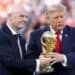 Balón de fútbol frente al logo de la FIFA en una asamblea con banderas de países miembro