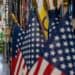 Surtidor de gasolina con precios en descenso frente a un panel de indicadores económicos de Estados Unidos