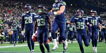Casco y logo de los Seattle Seahawks de la NFL sobre el césped de un estadio de fútbol americano
