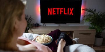 Pantalla con el logo de Netflix mostrando su catálogo de series y películas en un televisor