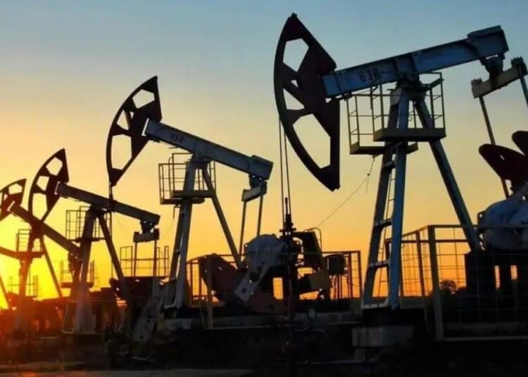 Barriles de petróleo y una plataforma de extracción de crudo con gráfico de precios al fondo