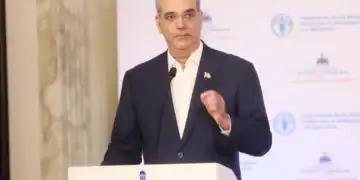 Campo agrícola dominicano con productores cosechando alimentos bajo el sol