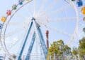 Familias disfrutan de atracciones en un parque temático de América Latina durante una jornada de verano