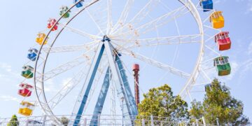 Familias disfrutan de atracciones en un parque temático de América Latina durante una jornada de verano