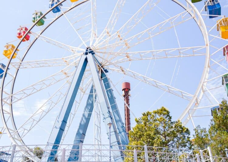 Familias disfrutan de atracciones en un parque temático de América Latina durante una jornada de verano