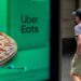 Repartidor con mochila de delivery en bicicleta usando una aplicacion de reparto de comida