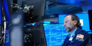 Pantallas de la Bolsa de Nueva York con índices en alza mientras cae el precio del petróleo