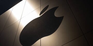 Tim Cook durante una presentación de Apple, con la pantalla de un iPhone al fondo
