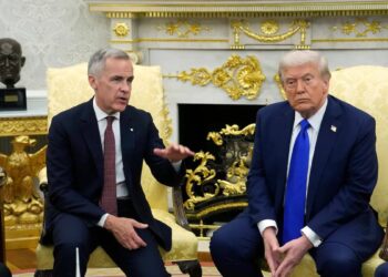 Donald Trump hablando ante periodistas sobre el acuerdo arancelario con Canadá frente a las obras de la Casa Blanca