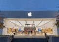 iPhone Pro sobre una mesa junto al logo de Apple en una tienda oficial, con modelos de entrada ausentes en el escaparate