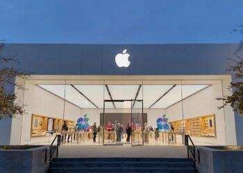 iPhone Pro sobre una mesa junto al logo de Apple en una tienda oficial, con modelos de entrada ausentes en el escaparate