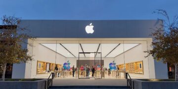 iPhone Pro sobre una mesa junto al logo de Apple en una tienda oficial, con modelos de entrada ausentes en el escaparate