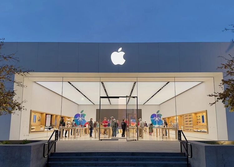 iPhone Pro sobre una mesa junto al logo de Apple en una tienda oficial, con modelos de entrada ausentes en el escaparate
