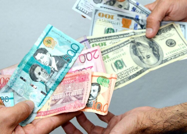 Billetes de dólares y pesos dominicanos sobre una mesa, con gráfica de tipo de cambio al fondo