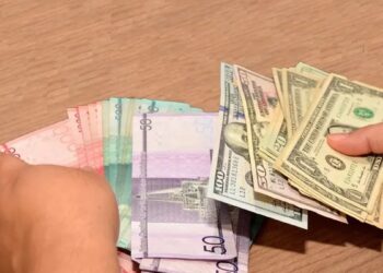 Billetes de pesos dominicanos y dólares estadounidenses sobre una mesa en Santo Domingo
