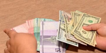 Billetes de pesos dominicanos y dólares estadounidenses sobre una mesa en Santo Domingo