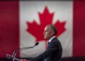 Banderas de Estados Unidos y Canadá frente a un puesto fronterizo comercial binacional