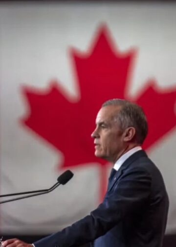 Banderas de Estados Unidos y Canadá frente a un puesto fronterizo comercial binacional