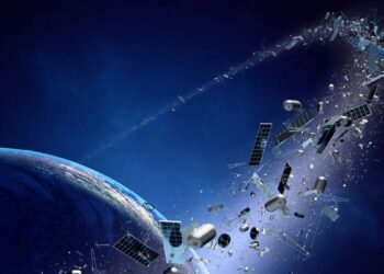 Satélite inservible flotando en órbita terrestre baja rodeado de fragmentos de basura espacial