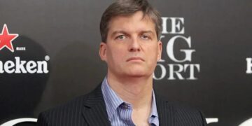Michael Burry y logo de Nvidia en pantalla de bolsa de valores con datos financieros en rojo