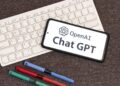 Joven adolescente usando ChatGPT en una laptop, con interfaz de OpenAI visible en pantalla
