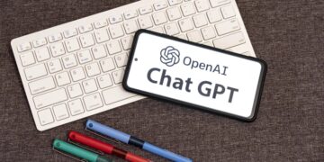 Joven adolescente usando ChatGPT en una laptop, con interfaz de OpenAI visible en pantalla