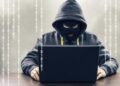 Persona revisando su tarjeta bancaria frente a una computadora tras detectar cargos no autorizados en República Dominicana