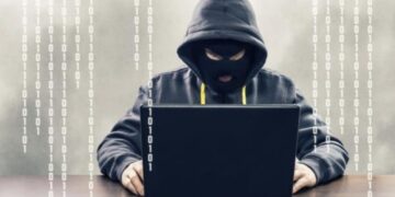 Persona revisando su tarjeta bancaria frente a una computadora tras detectar cargos no autorizados en República Dominicana