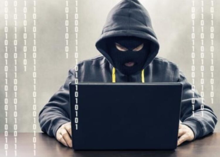 Persona revisando su tarjeta bancaria frente a una computadora tras detectar cargos no autorizados en República Dominicana