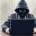Persona revisando su tarjeta bancaria frente a una computadora tras detectar cargos no autorizados en República Dominicana