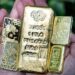 Lingotes de oro apilados sobre una superficie reflectante con el símbolo del dólar al fondo