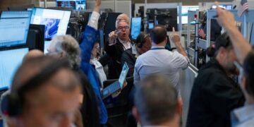 Operadores en la Bolsa de Nueva York revisando pantallas con datos del mercado durante una jornada alcista en Wall Street