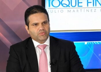 Contenedores de exportación en puerto dominicano con tendido eléctrico al fondo