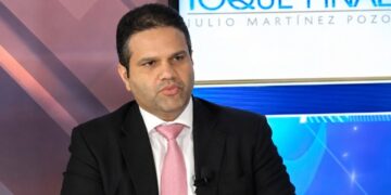 Contenedores de exportación en puerto dominicano con tendido eléctrico al fondo