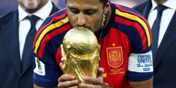 Rodri, mediocampista español del Manchester City, celebra un título con el trofeo en mano