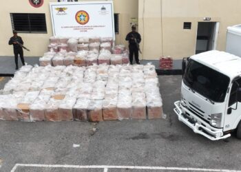 Agentes del Ceccom junto a tanques de gasoil y cajas de cigarrillos decomisados en operativo del MICM en República Dominicana
