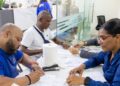 Exmiembros de la Policía Nacional de República Dominicana recibiendo cheques de indemnización por retiro en el Ministerio de Hacienda
