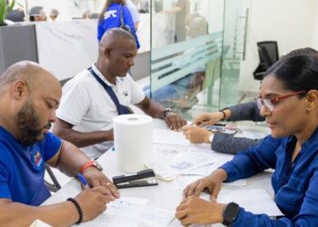 Exmiembros de la Policía Nacional de República Dominicana recibiendo cheques de indemnización por retiro en el Ministerio de Hacienda