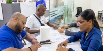 Exmiembros de la Policía Nacional de República Dominicana recibiendo cheques de indemnización por retiro en el Ministerio de Hacienda